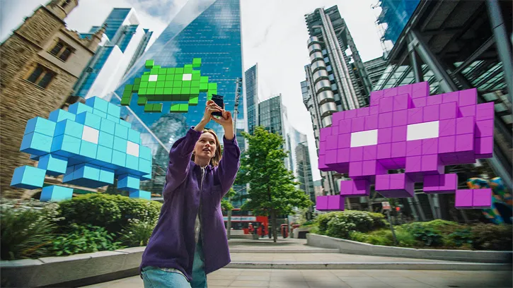 Female player defending London from 3D Space Invaders in augmented reality