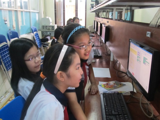 Photo montrant trois jeunes filles vietnamiennes devant un ordinateur.