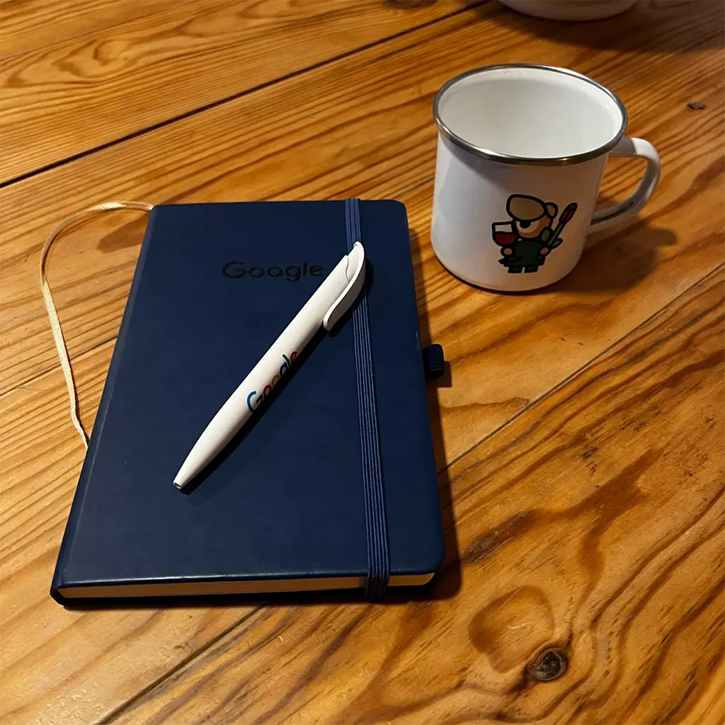 A photo of a notebook, a pen and a mug. alt_text