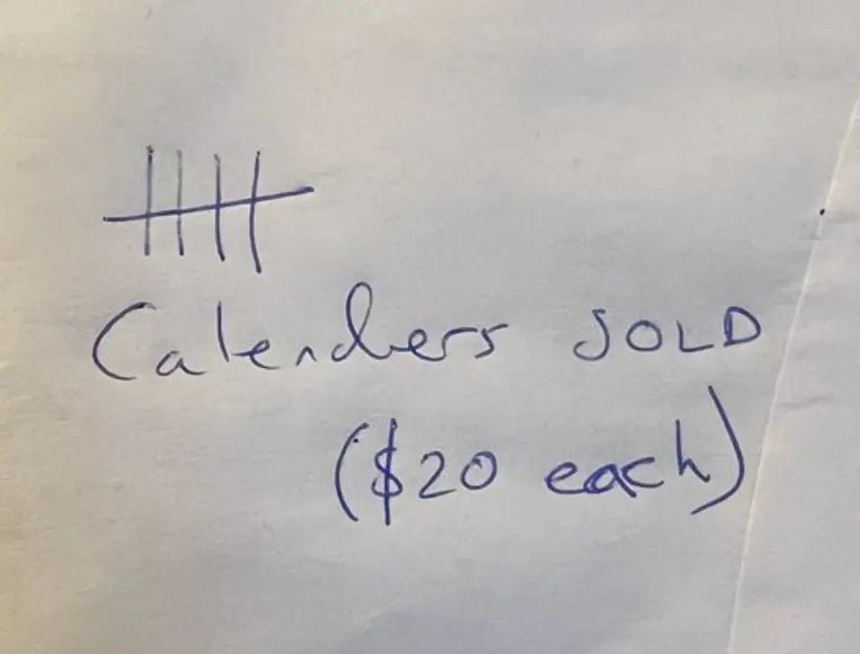 A photo of a piece of paper with a tally of 5 and the words: Calendars SOLD ($20 each). alt_text